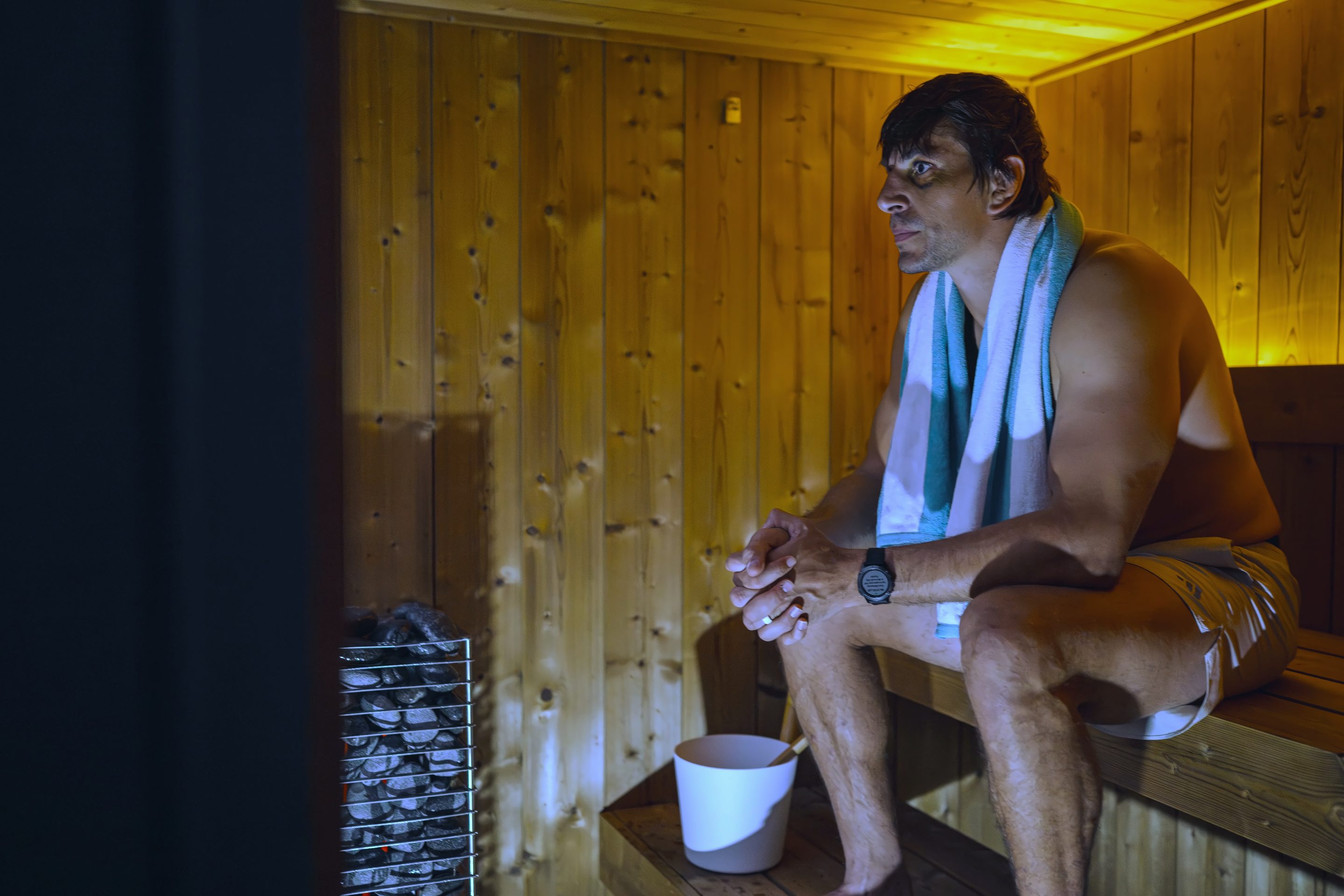 Eben Etzebeth sitting in a wood-panelled sauna with a towel around his neck: Swoop Social shoot