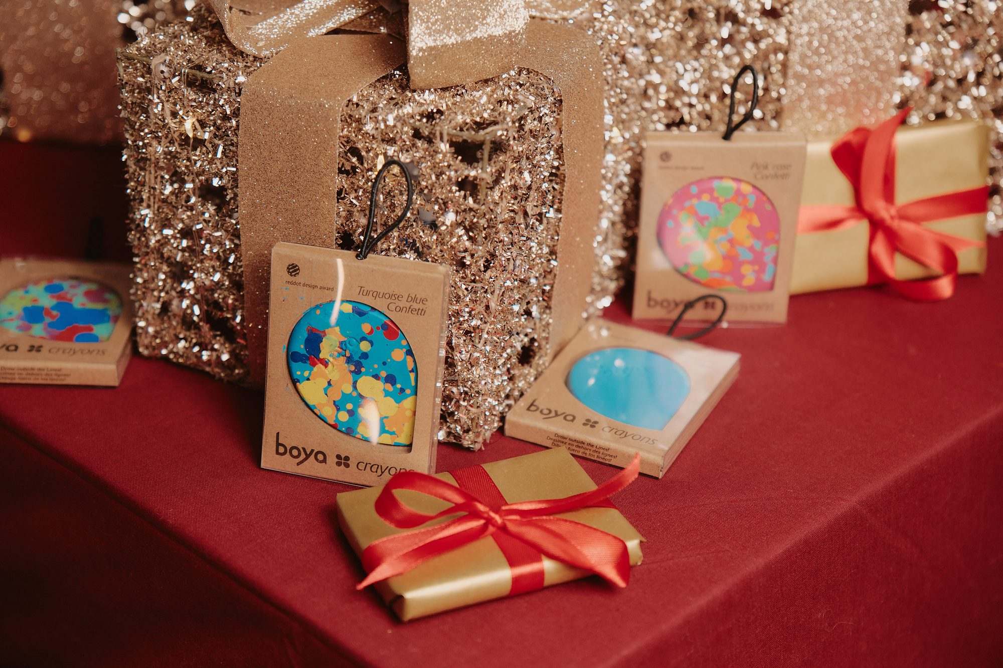 Boya: Boya products gift-wrapped on a red table with gold paper