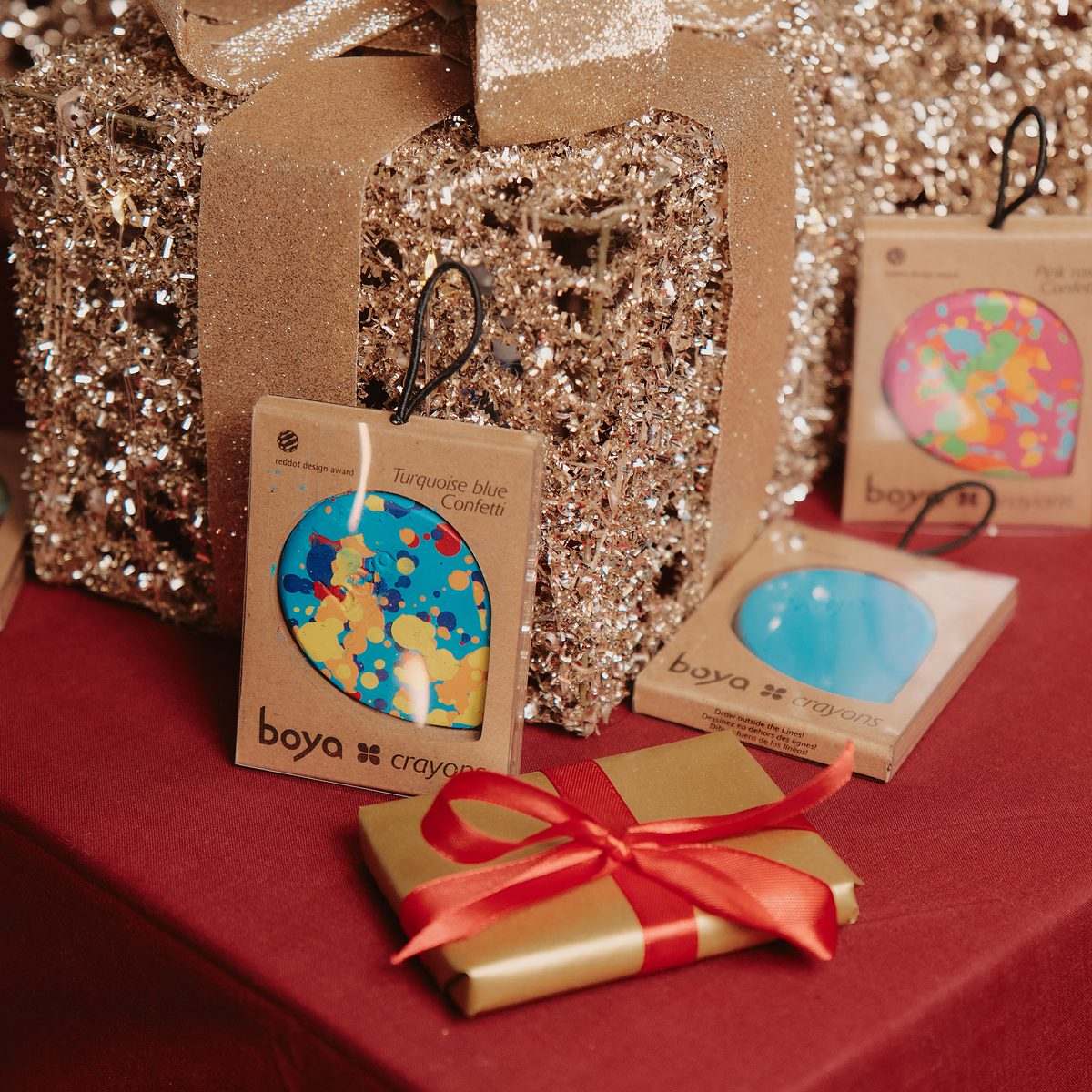 Boya Christmas campaign: gift-boxed Boya products on a red table with gold wrapping