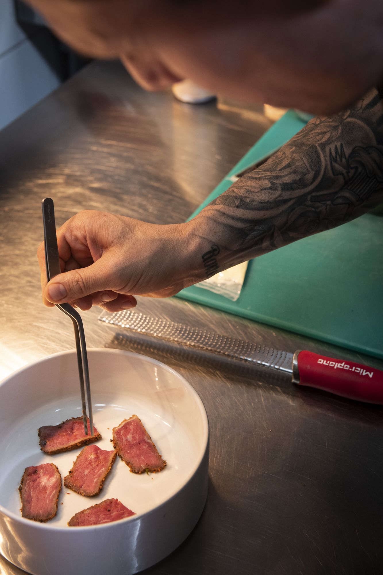 Double Dutch: Chef plating seared meat into a bowl