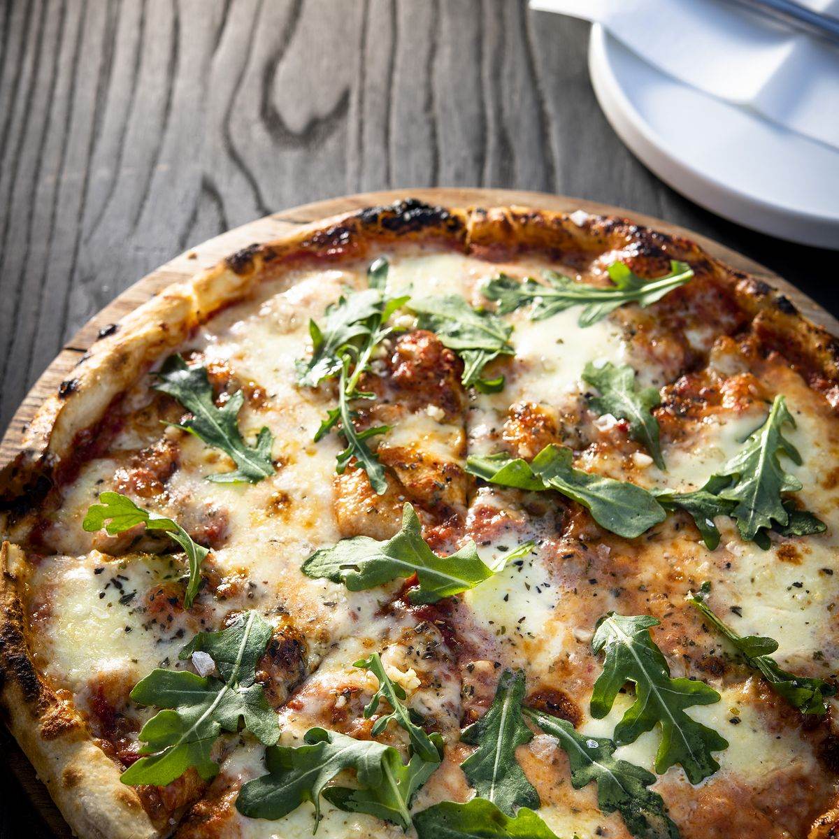 Double Dutch food photography: rocket-topped pizza on a wooden table