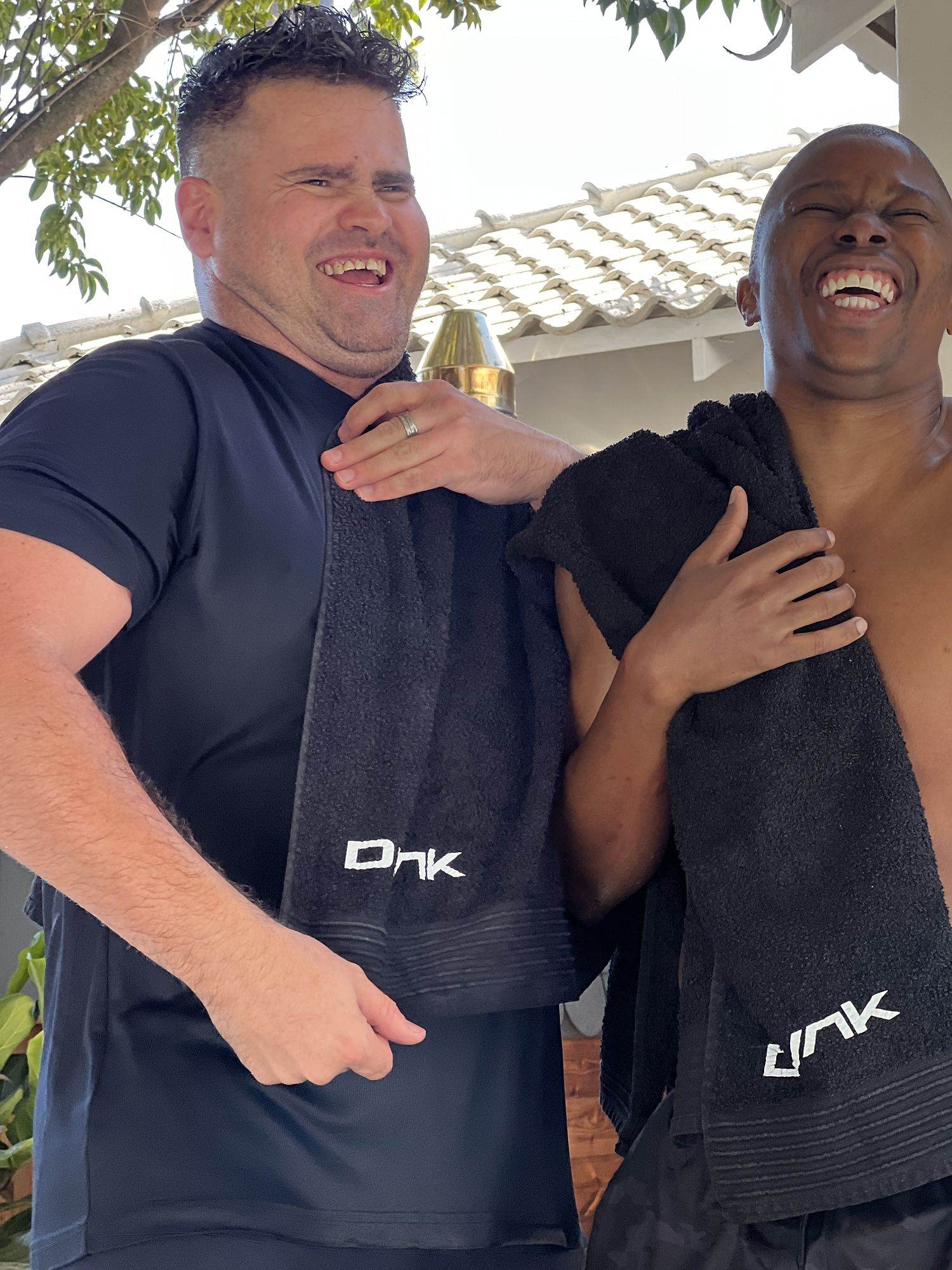 Dunk: Two men smiling with Dunk towels over their shoulders
