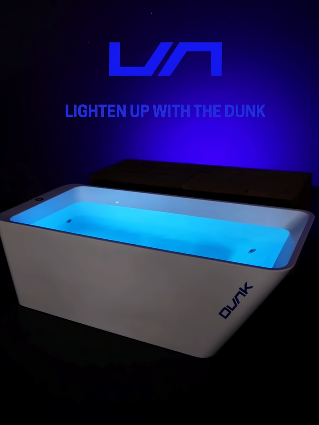 Dunk: Dunk ice bath lit cyan in a dark room under the projected words Lighten up with the Dunk