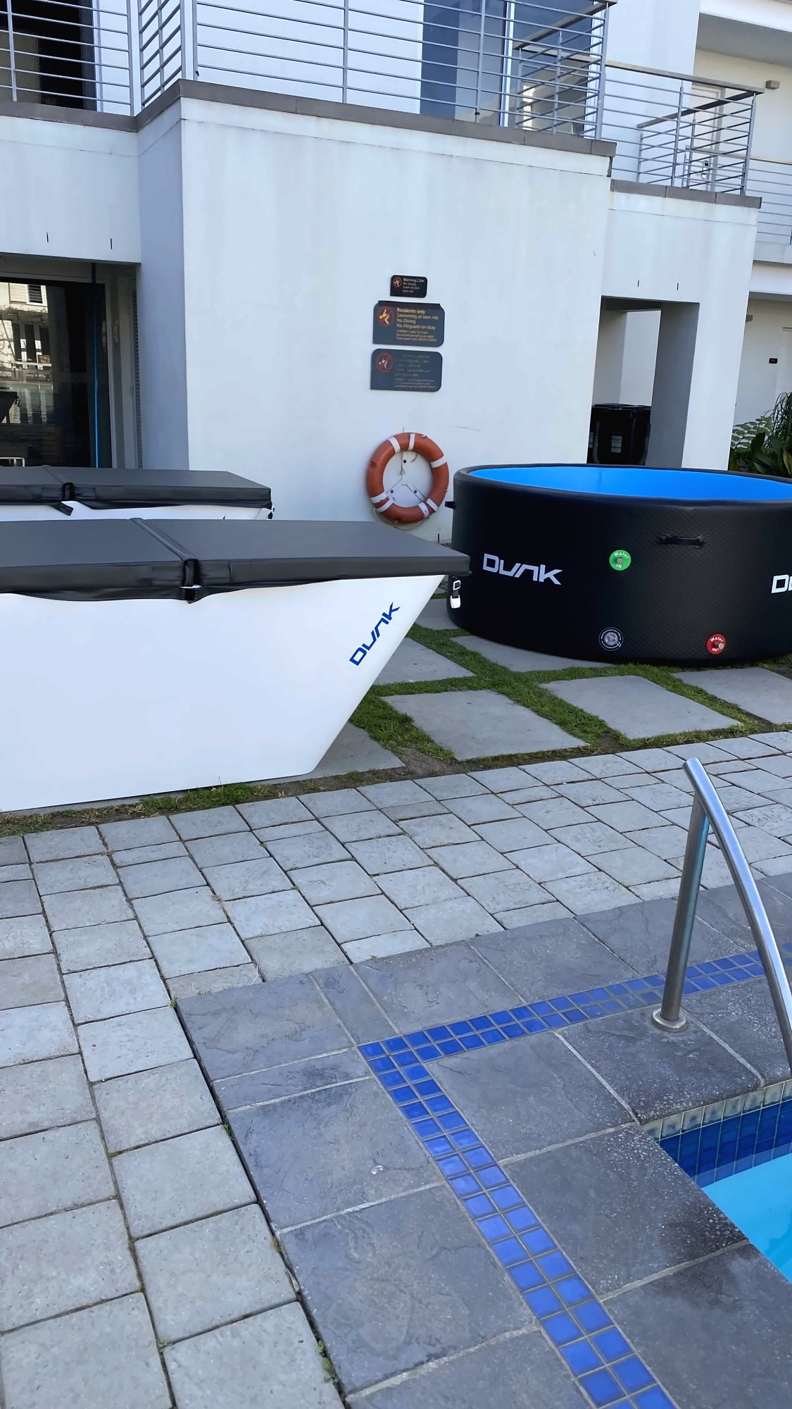 Dunk: White Dunk ice bath and a black inflatable Dunk beside a pool