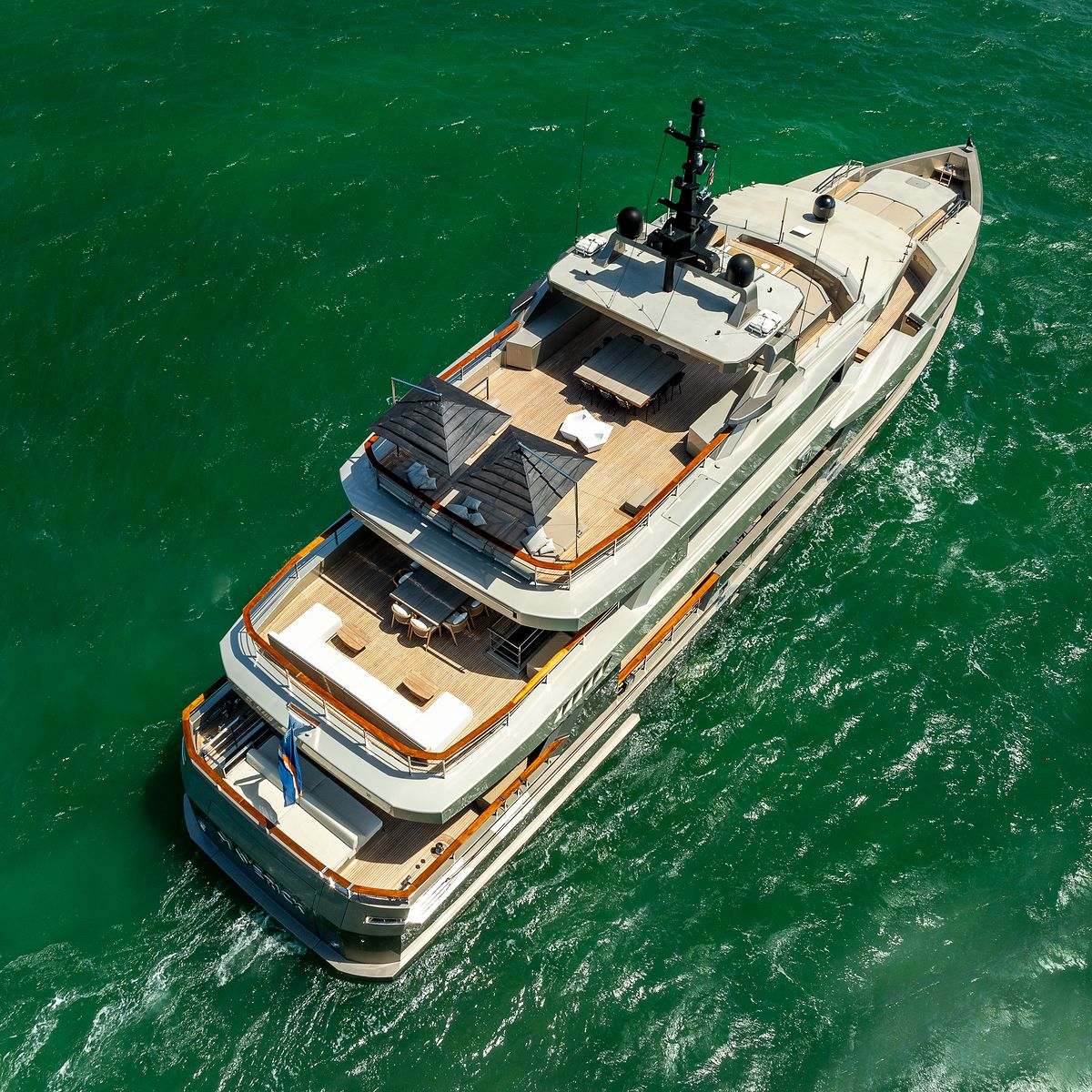 Superyacht Maverick from above, cruising across emerald-green water