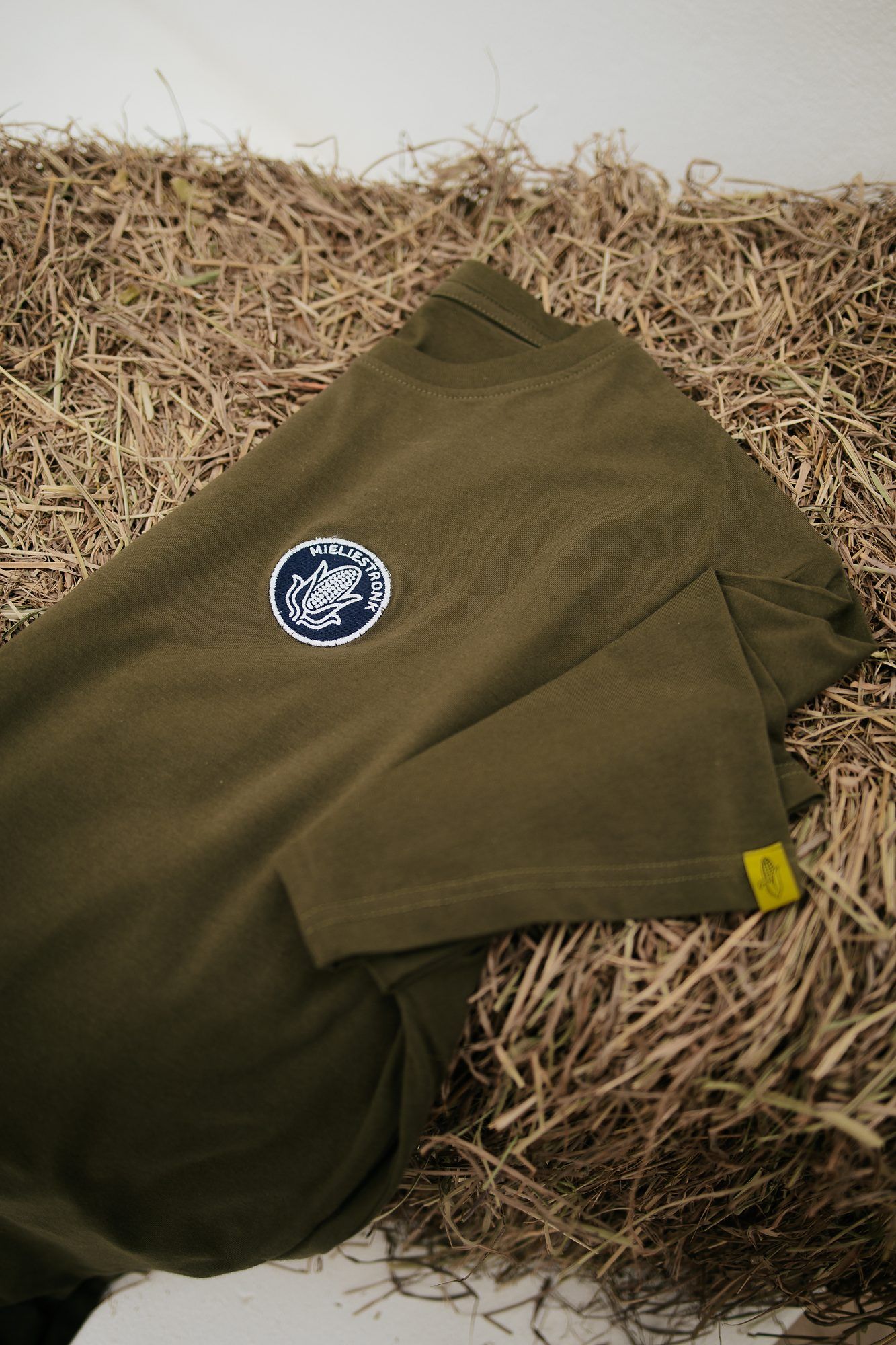 Mieliestronk: Olive Mieliestronk tee laid flat on hay