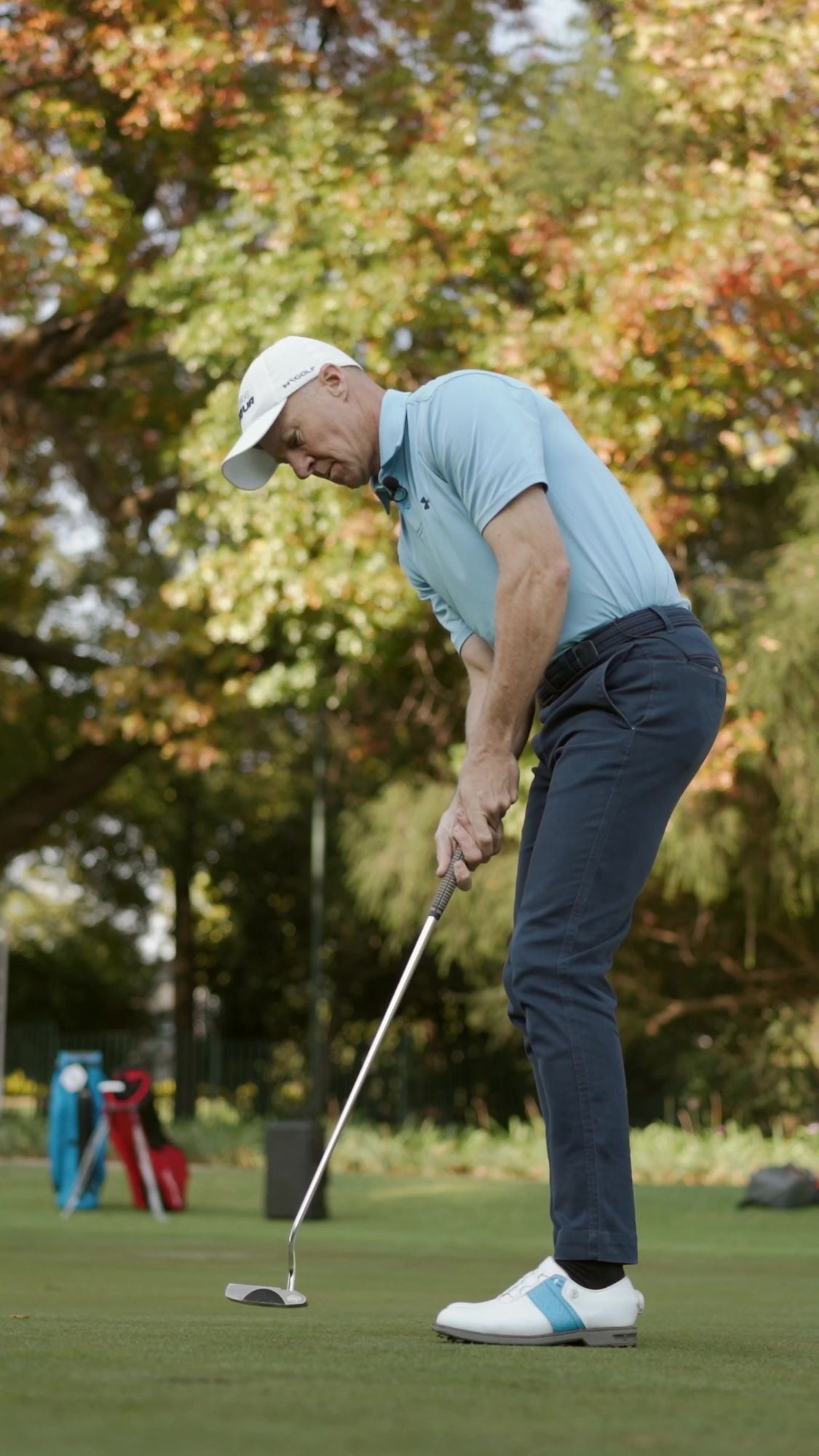 My Golf Pro: Golfer lining up a putt on the green under autumn trees