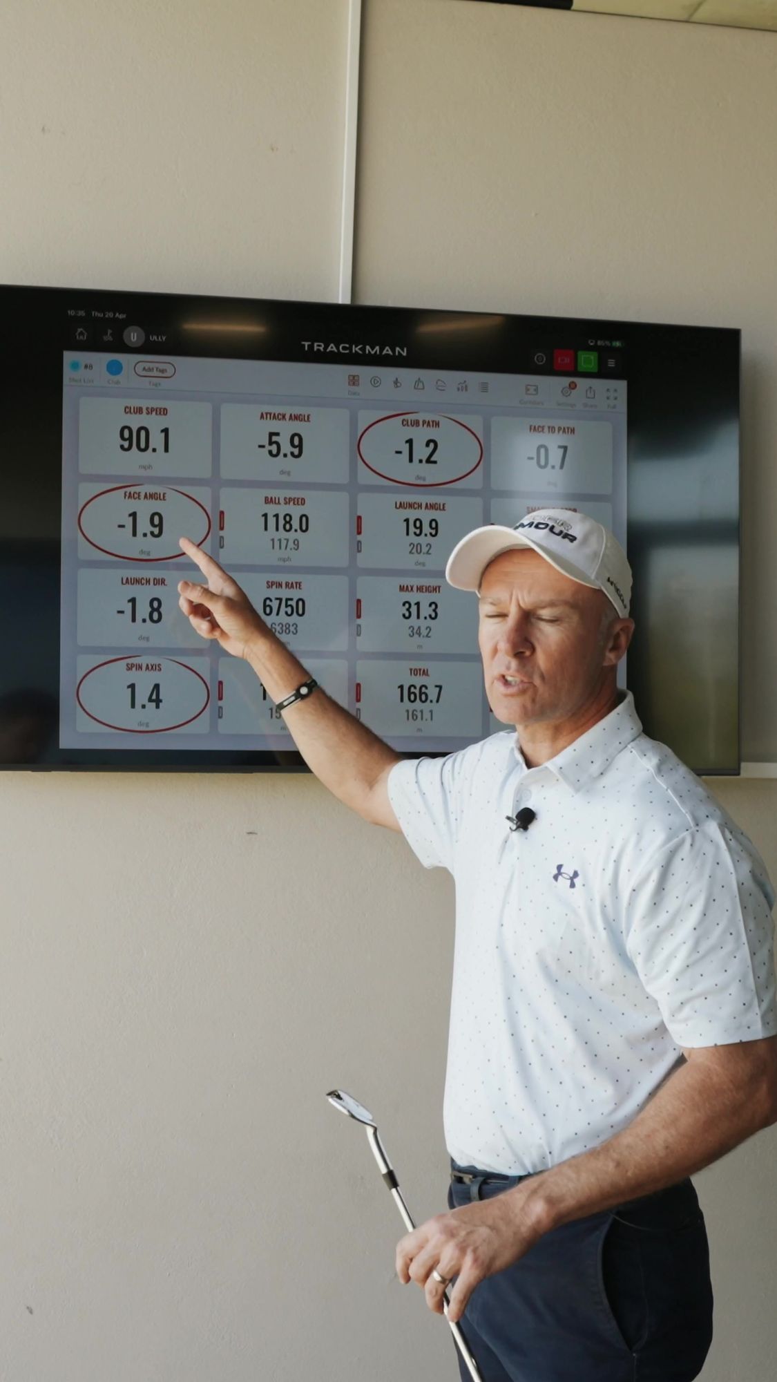 My Golf Pro: Coach pointing at Trackman data on a screen