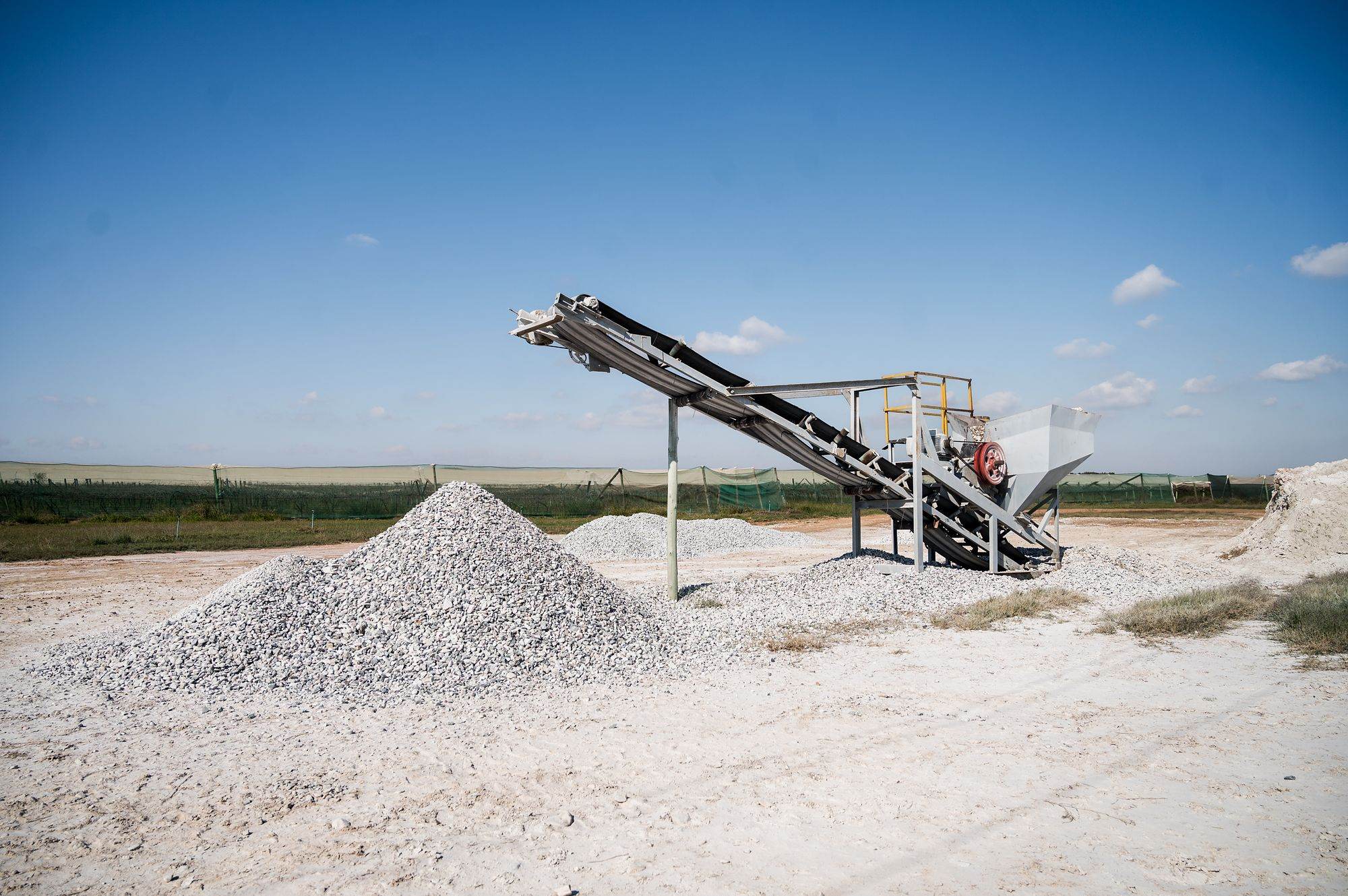 Pebble Africa: Conveyor building a pile of white pebbles under a blue sky