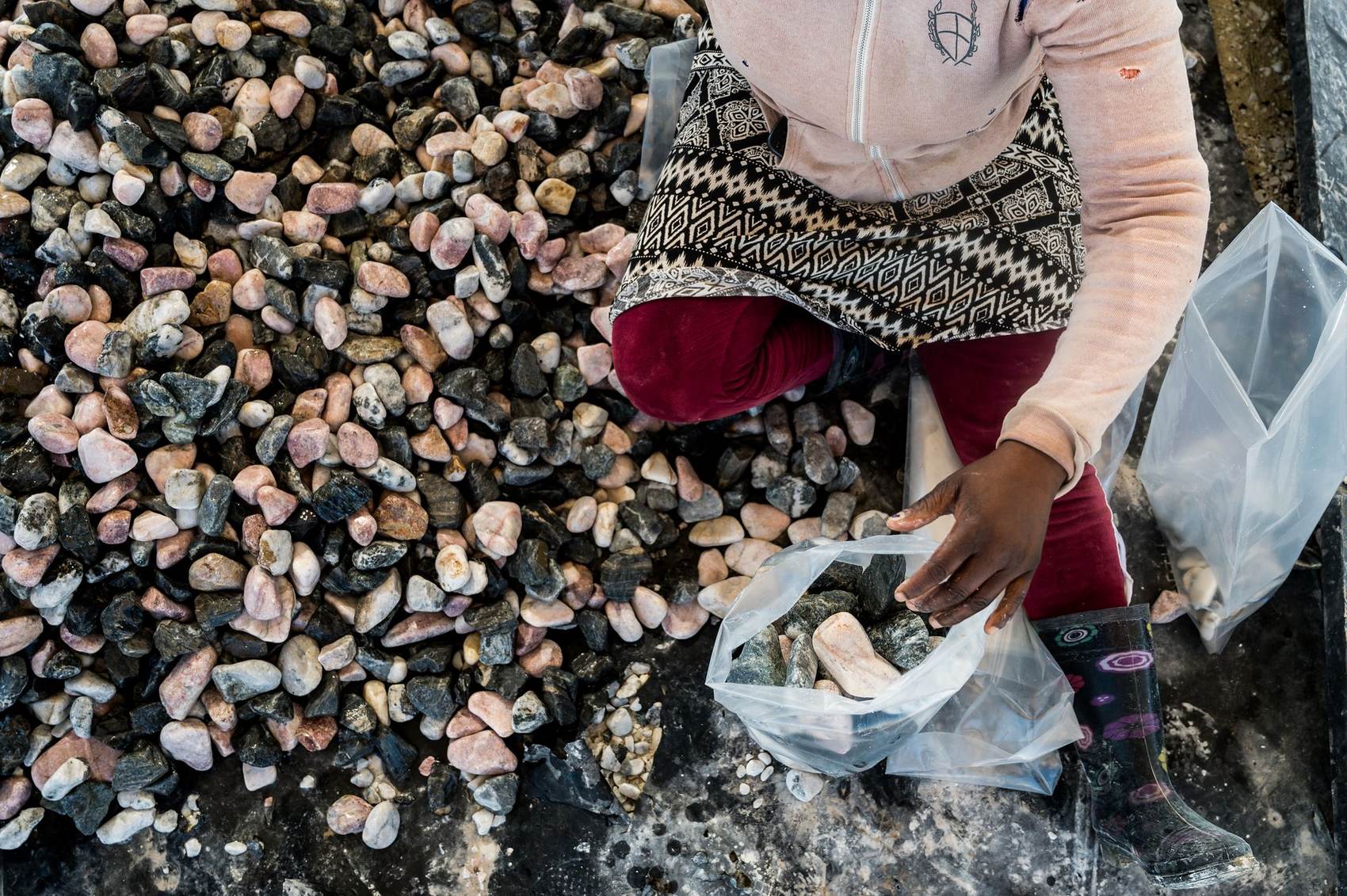 Pebble Africa: Worker sorting pebbles into a bag by hand