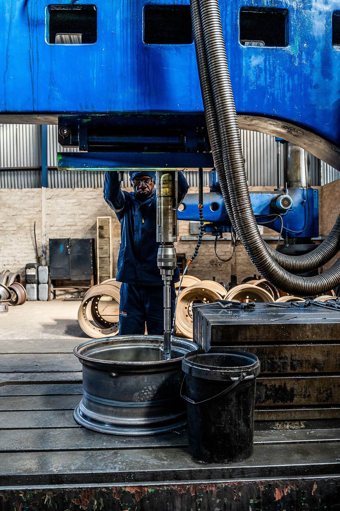 Q Tyres: Wheel rim on a workbench under a blue machine in the workshop