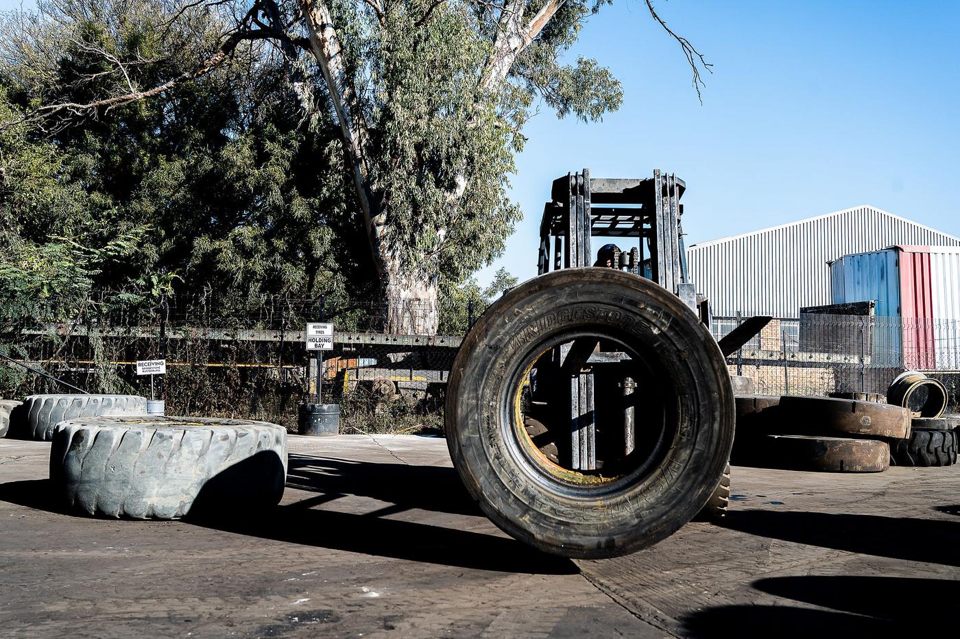 Q Tyres: Forklift handling a large truck tyre in the yard