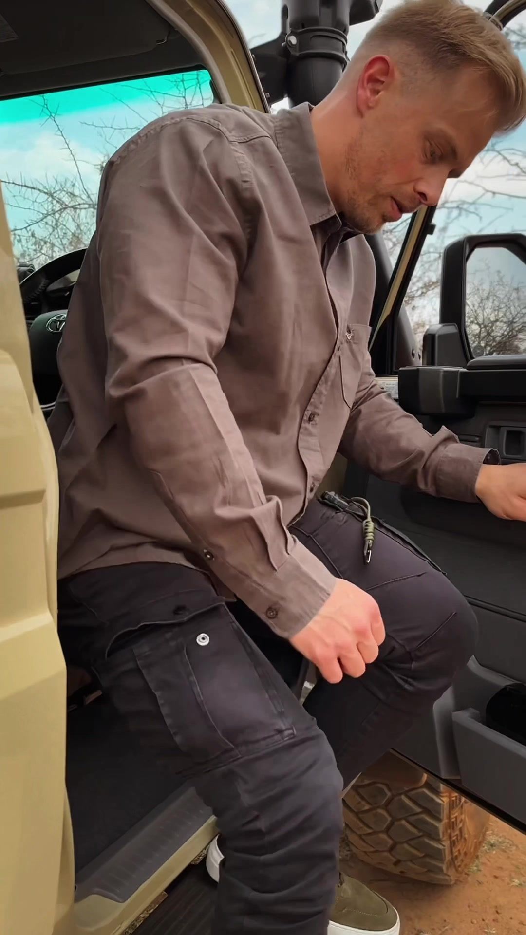 Safari Outdoor: Man in a brown shirt stepping out of a safari vehicle