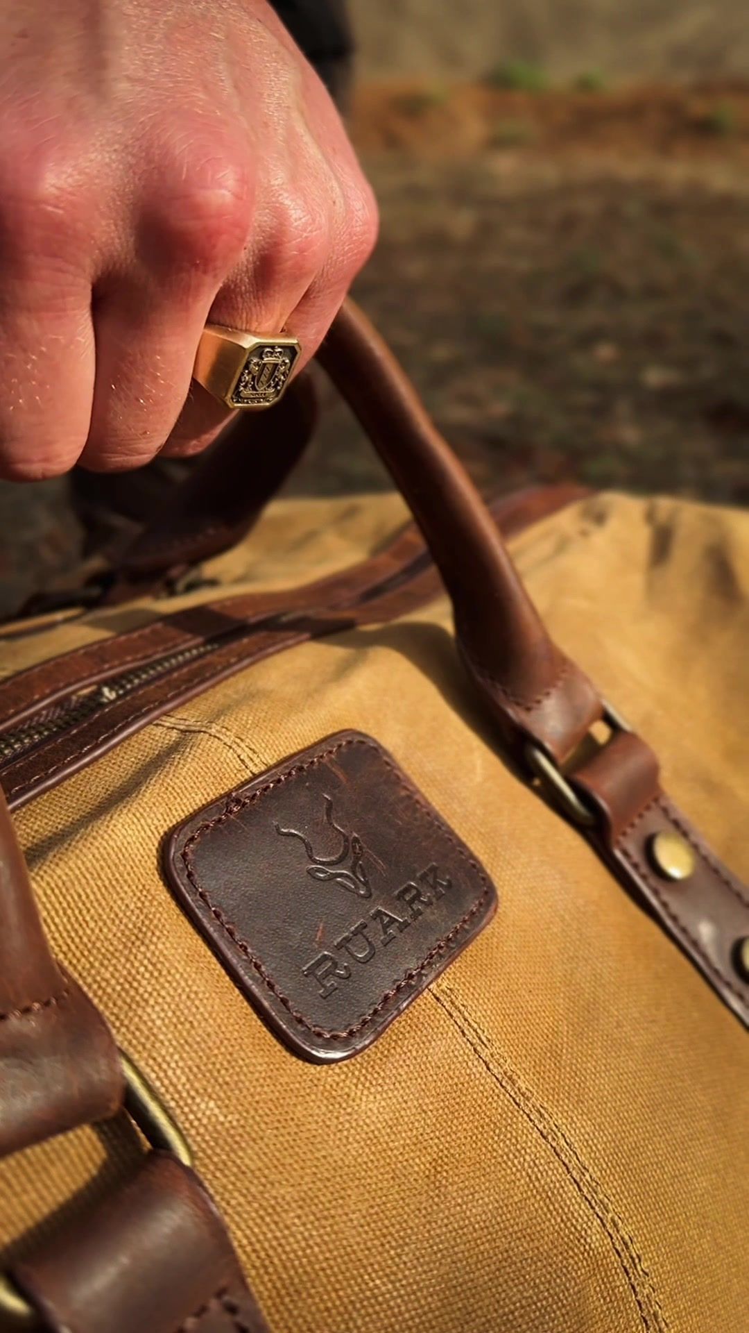 Safari Outdoor: Hand on the leather strap of a canvas bag