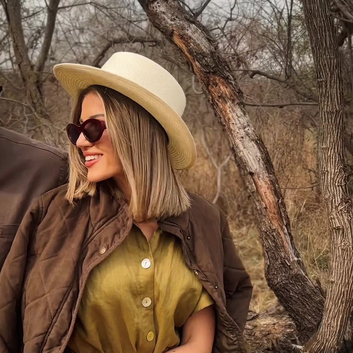 Safari Outdoor lifestyle shoot: woman in a wide-brim hat and olive outfit in the bushveld